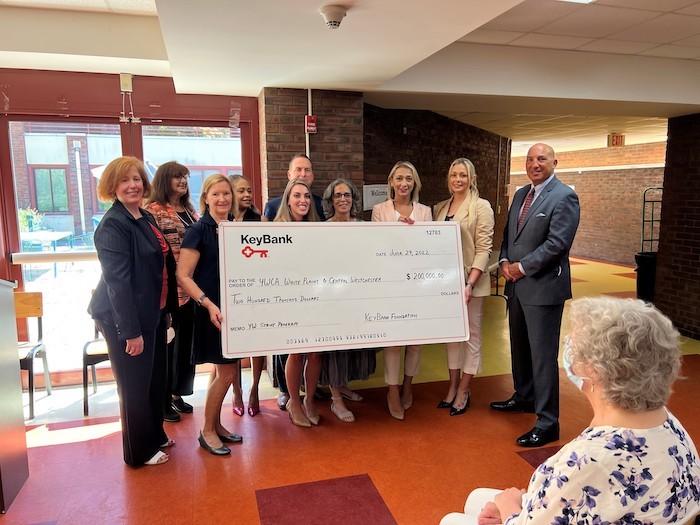 Group of people hold a large KeyBank check