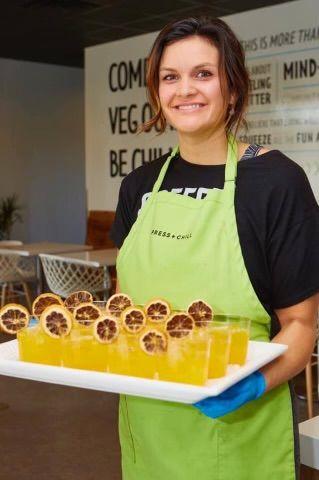 Kimberly Hoffmann wearing an apron, holding a tray of drinks.