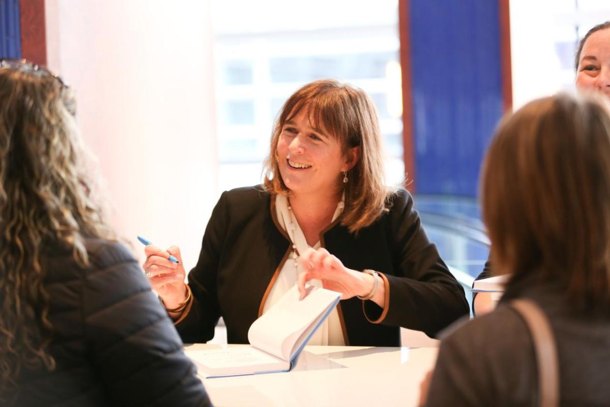 WHC President Margaret O'Gorman signing copies of Strategic Corporate Conservation Planning