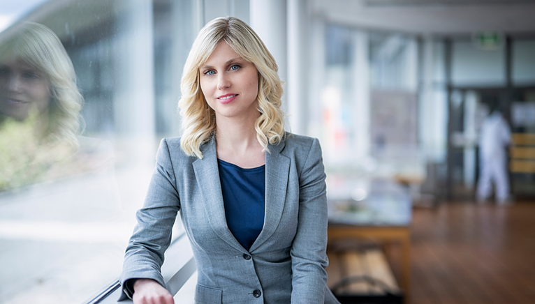 Martina Flemstrom leaning against a window sill in an office setting.