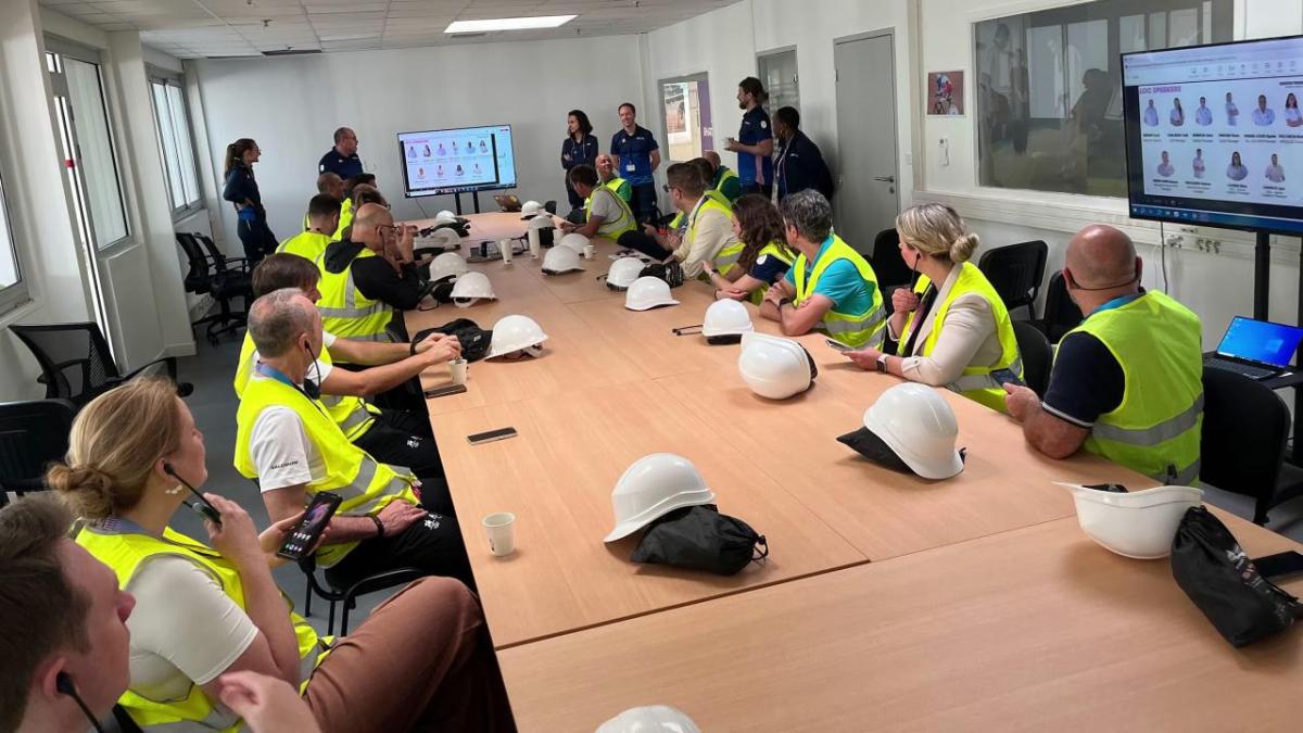 People wearing hi-vis vests sat around a large table 