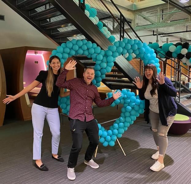 Megan Roder with her GoDaddy team. A heart made out of balloons is shown.