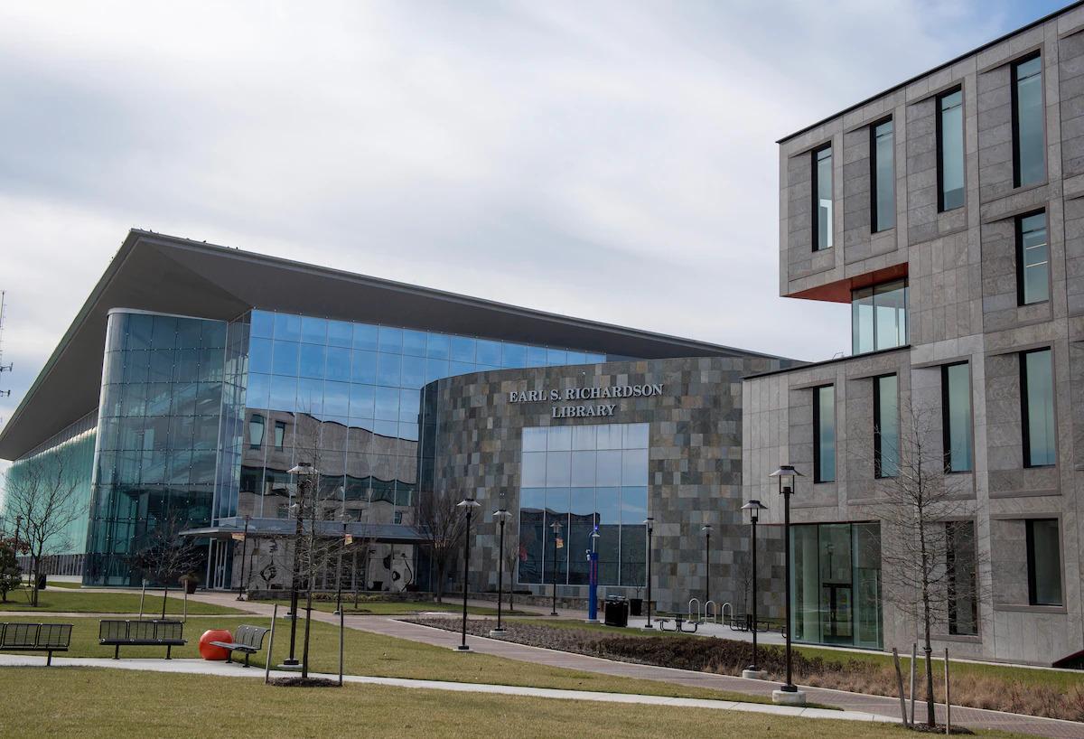 Exterior of the Earl S. Richardson Library. Grassy area with park benches in front of it.