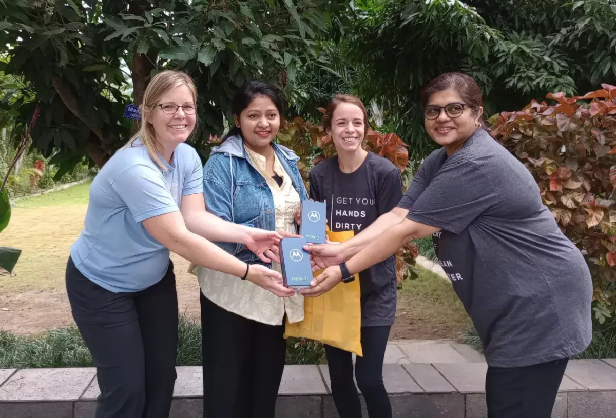 Four people smiling and holding Moto G boxes