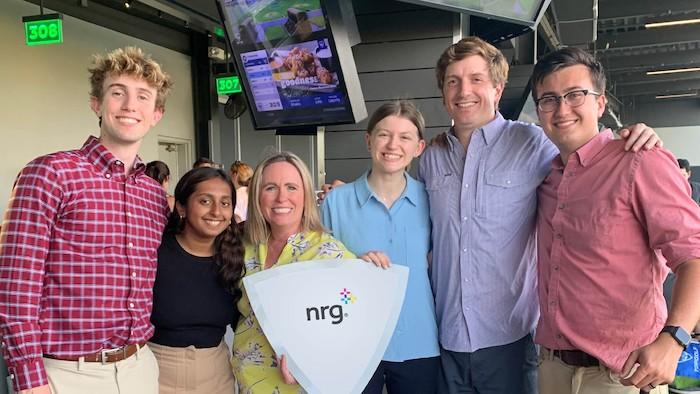 NRG Interns shown holding the NRG logo.