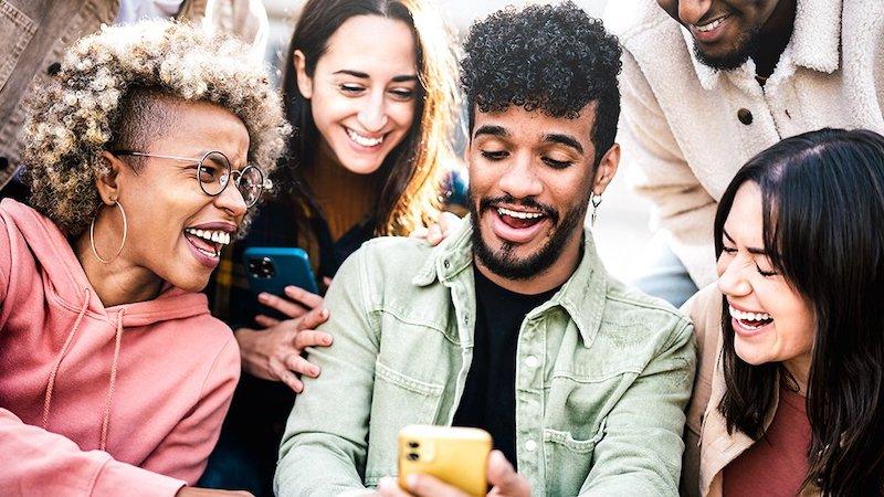 Group of young people looking at their phones.