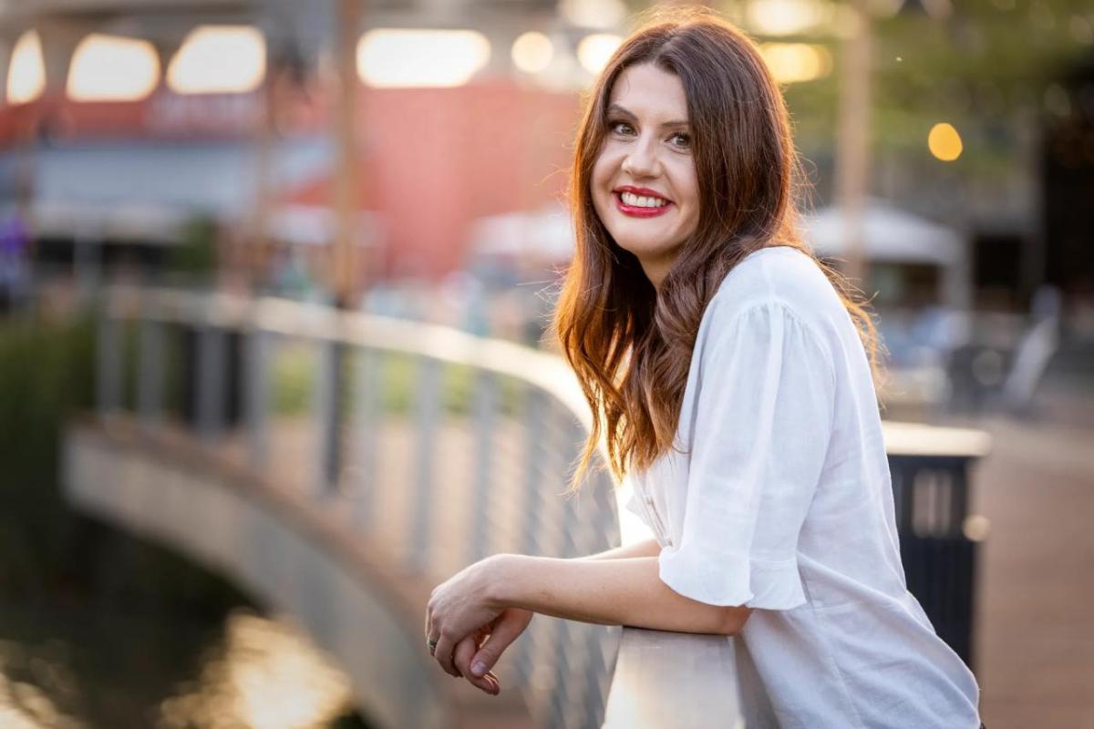 Nikki Jolly stood resting their arms on a bridge railing