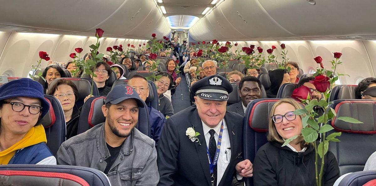 Aeroplane passengers holding roses gifted by Capt. Wayant on mother's day