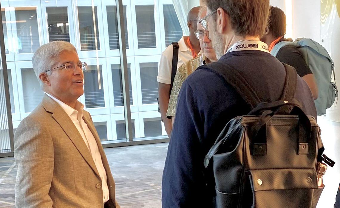 Pedro Pizarro talking with others in an open room with large windows behind them.