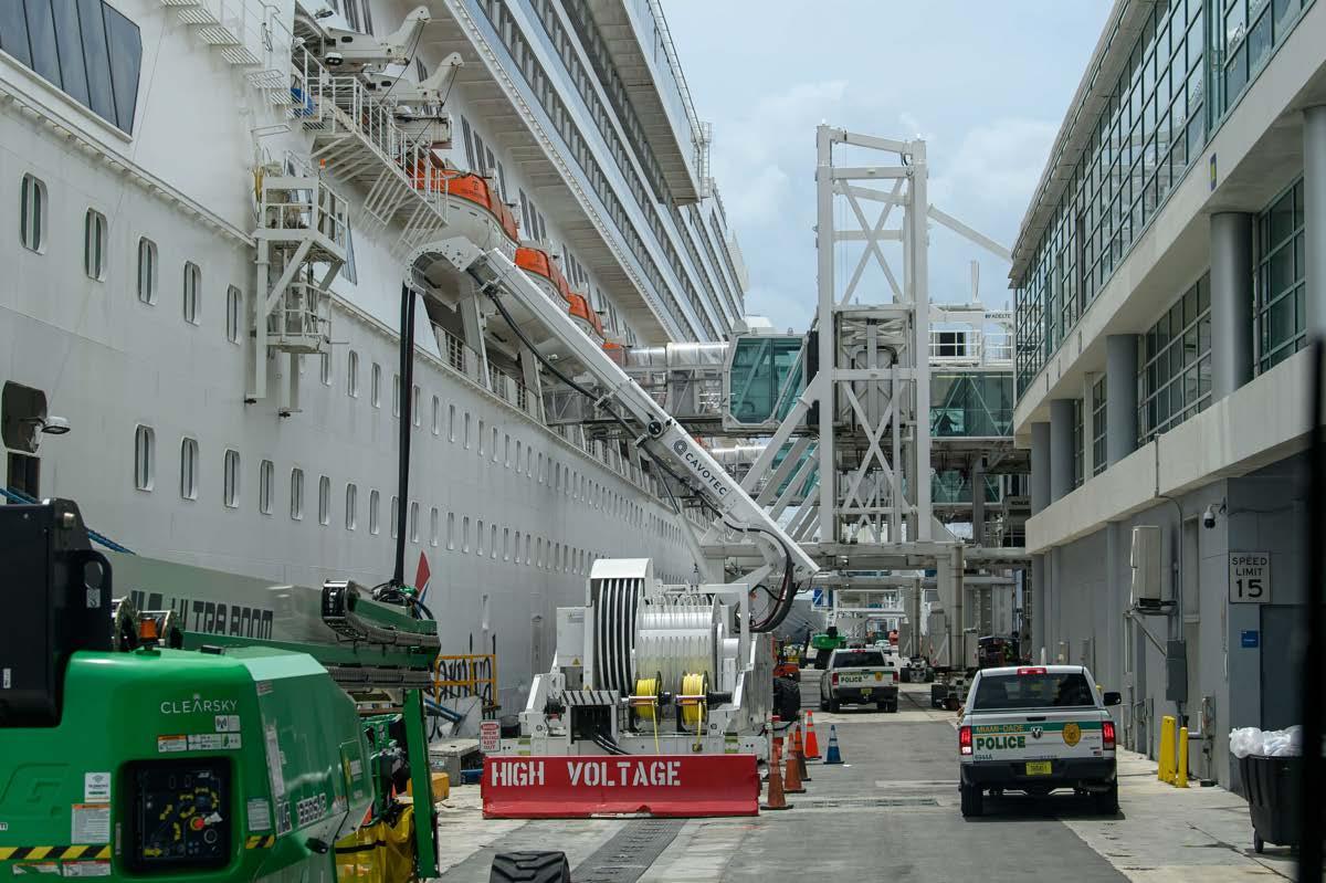 A large boat docked near a narrow roadway and building.