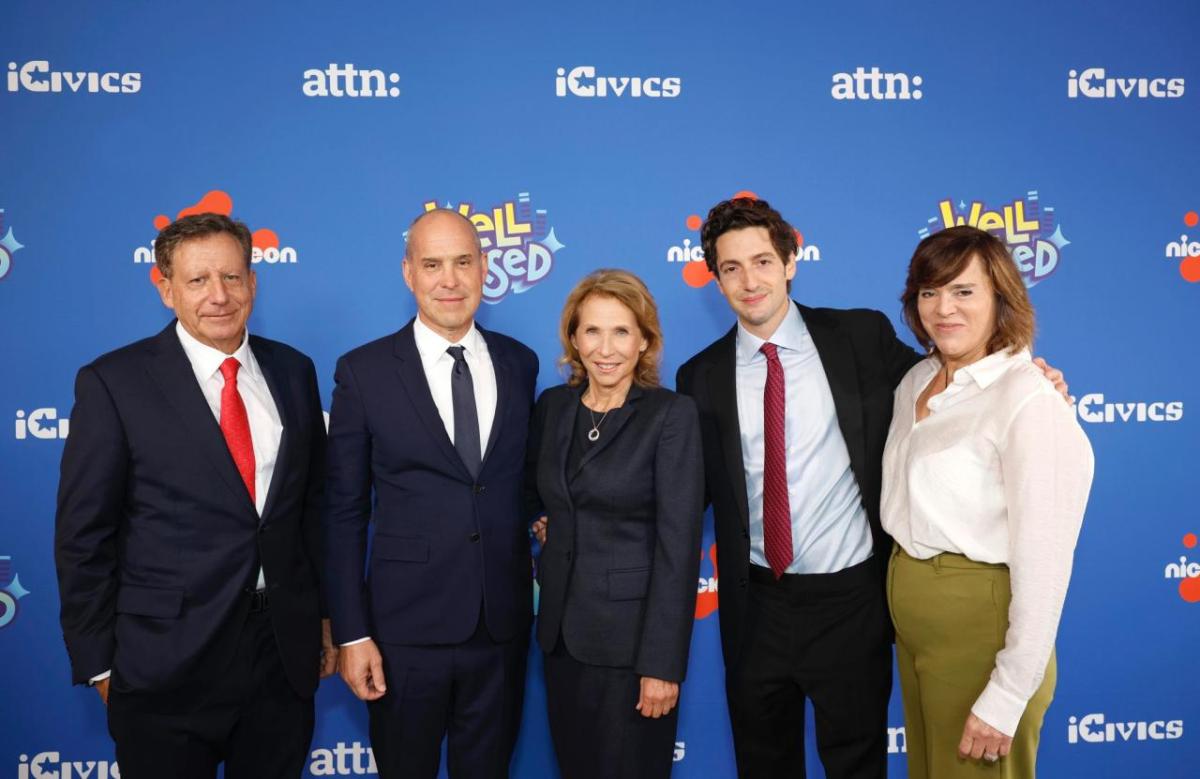 five people stood together in front of a nickelodeon logo backdrop