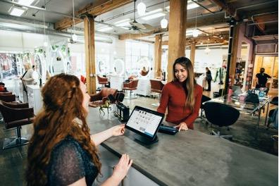 Two females at a table with a tablet.