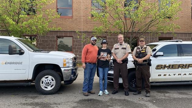 Two people stood next to two Sheriff’s and their cars