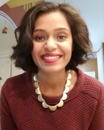 Photo of Renu Zunjarwad in a red sweater