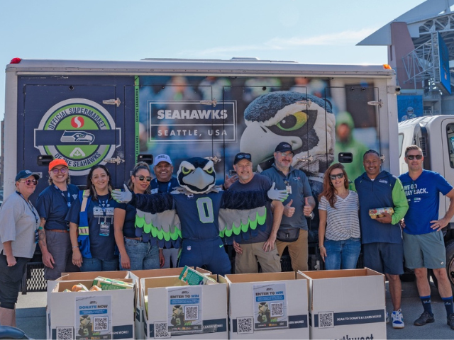 Group of people posing with food donation boxes