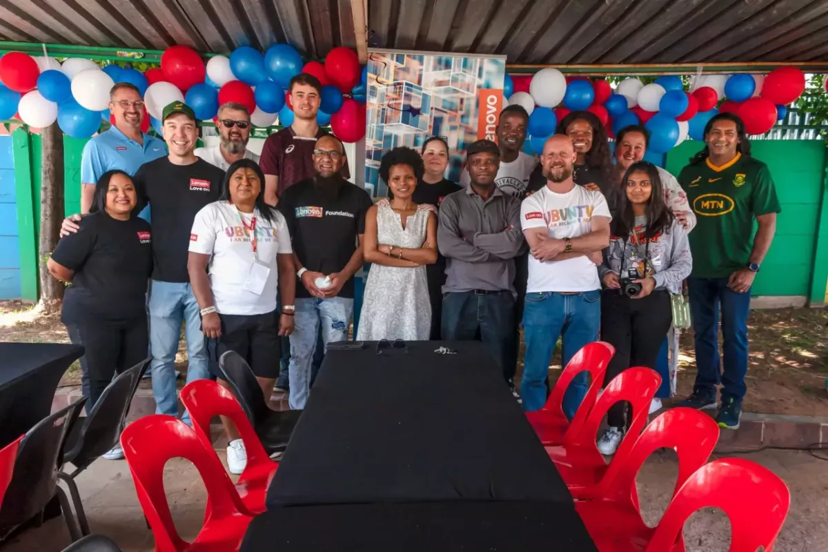 Group of people stood together for a photo, in front of a balloon garland