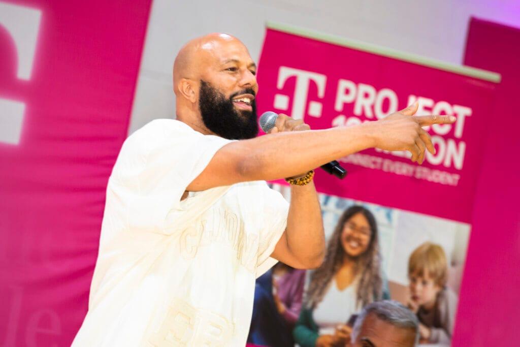 A person talking in to a microphone while pointing 