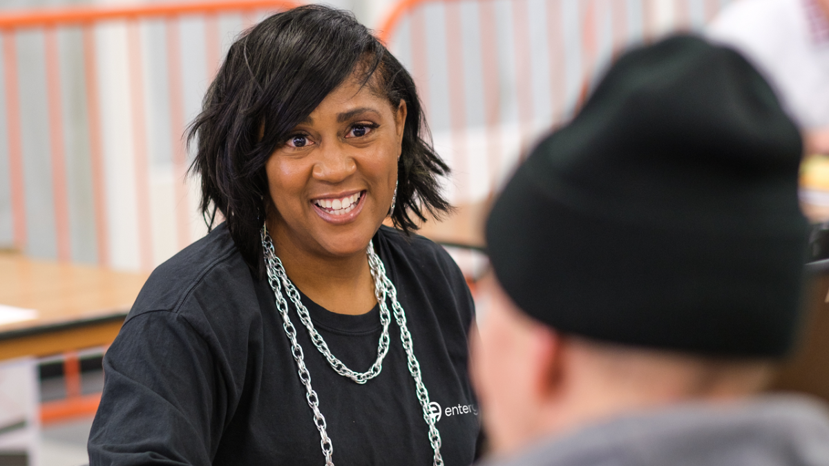 An Entergy employee smiling at a person sitting across from them.