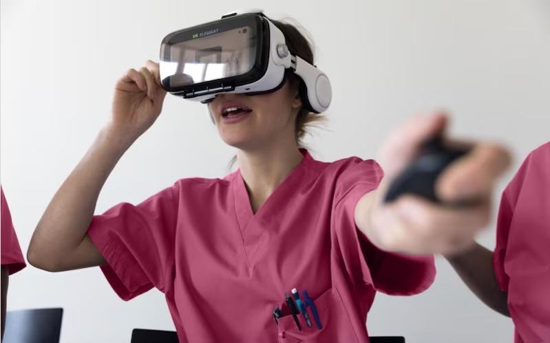 Female technician shown wearing virtual reality glasses and wearing scrubs.