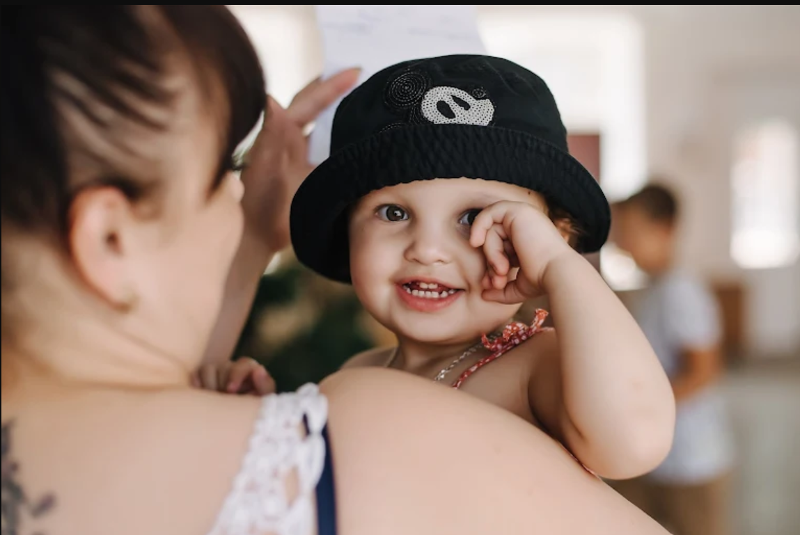 A young child smiles while being held by their mother at a mobile clinic held in Ukraine.