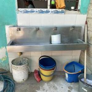 Sink with three buckets lined up underneath