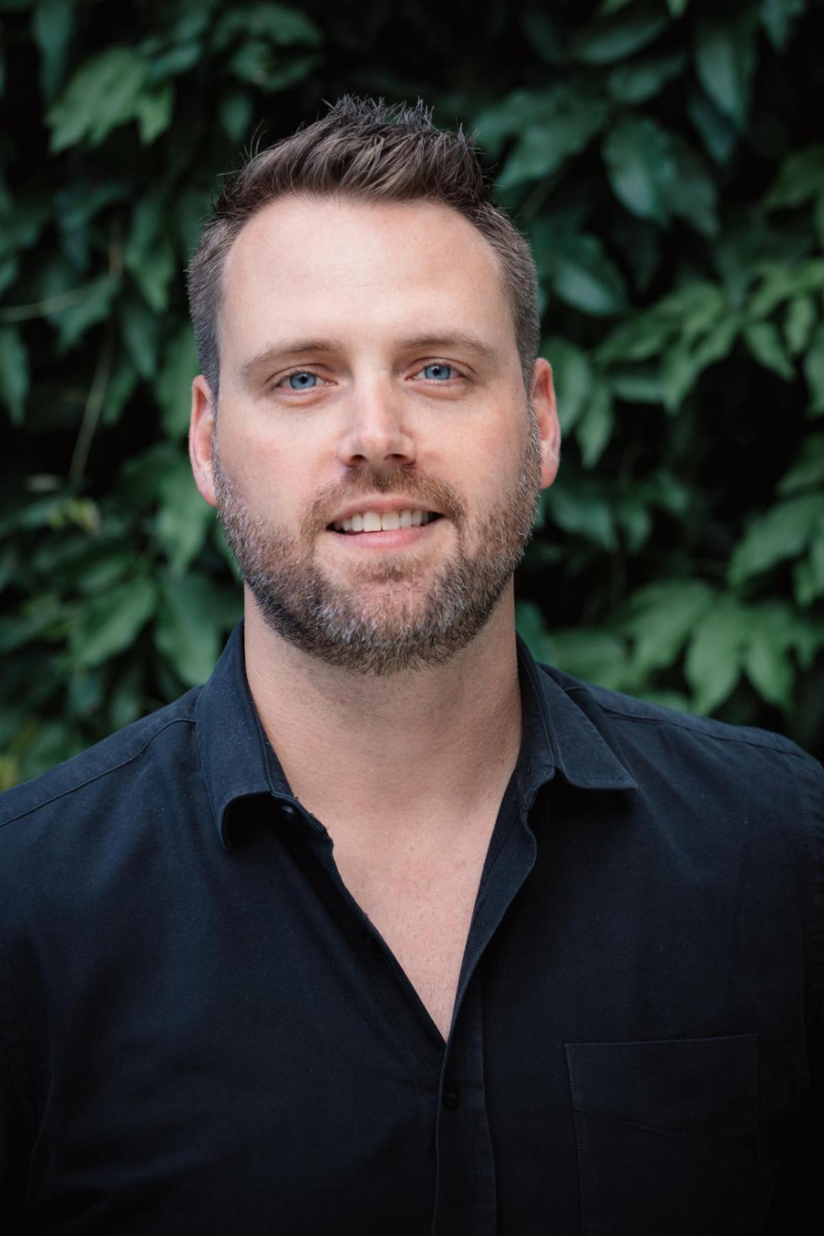 Headshot of Matthew Wemple against a background of leaves