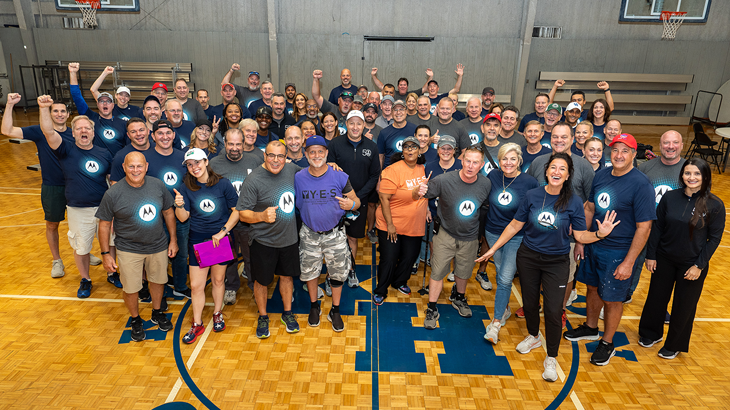 Group of volunteers wearing Motorola shirts standing in gym