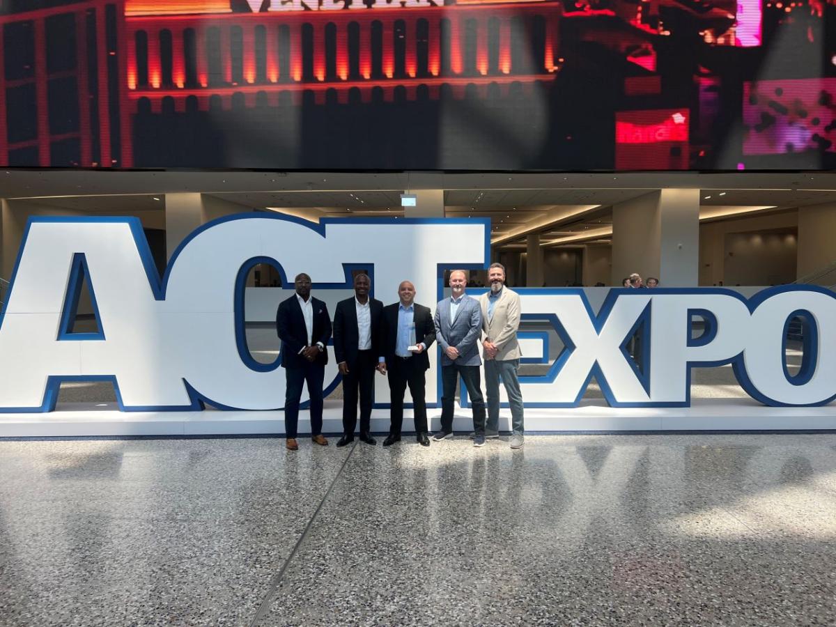 Five people posed with an award in front of a large "ACTExpo" sign.