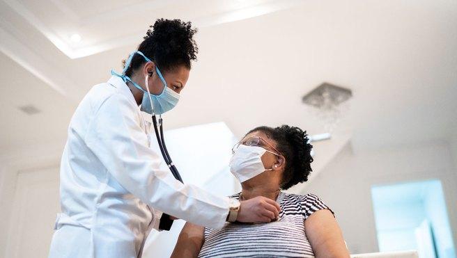 doctor using stethoscope on patient