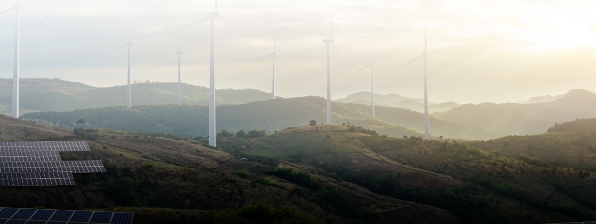 Mountains in the distance with wind turbines and a solar farm