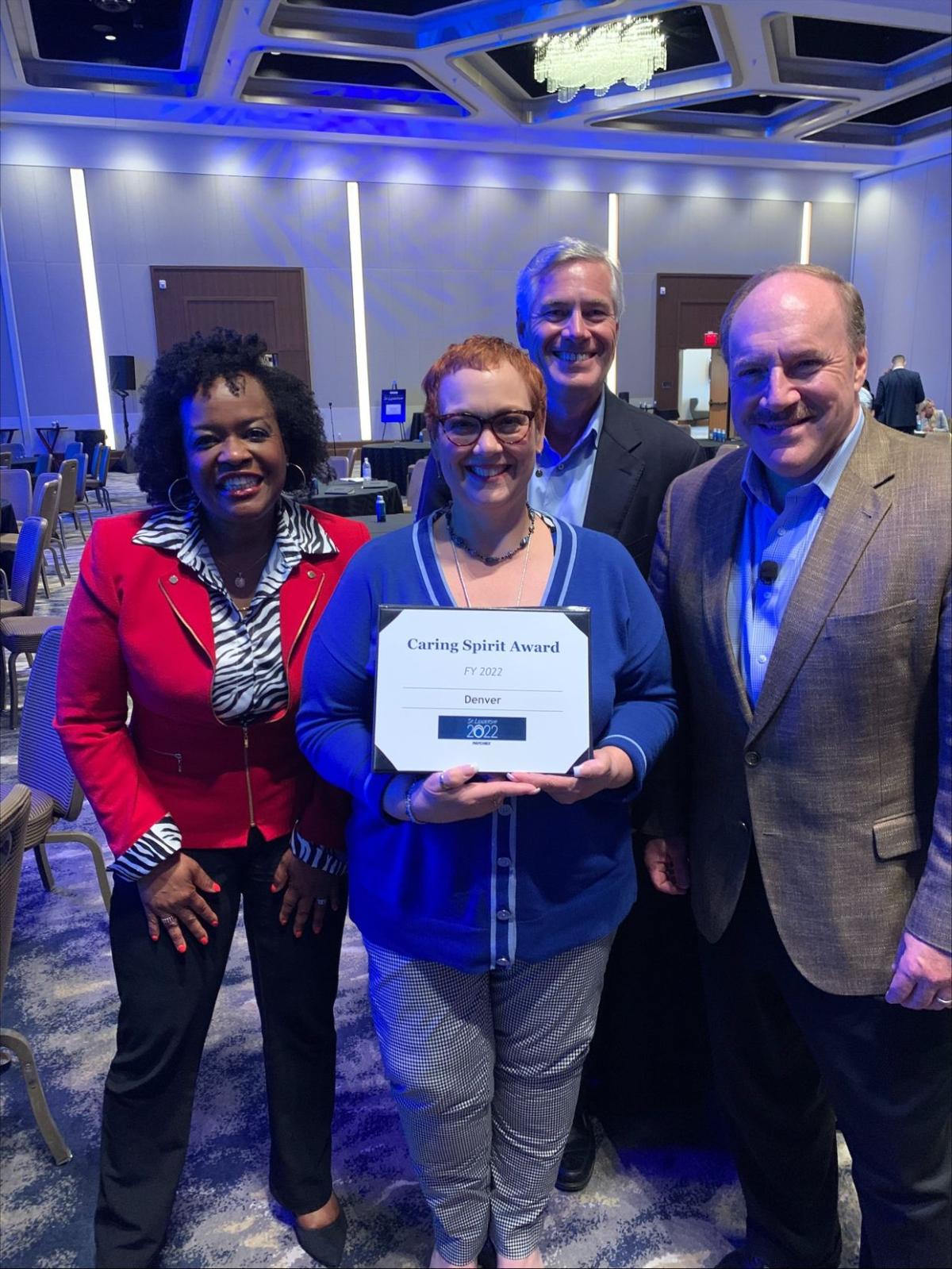 Four employees posing with Caring Spirit Award