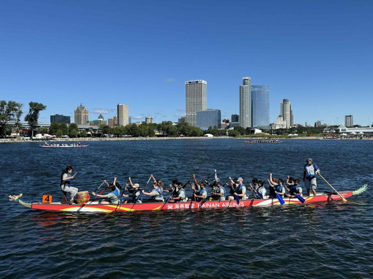 A group in a long boat paddling on a body of water.