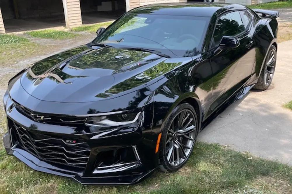 A black car parked in a grassy area