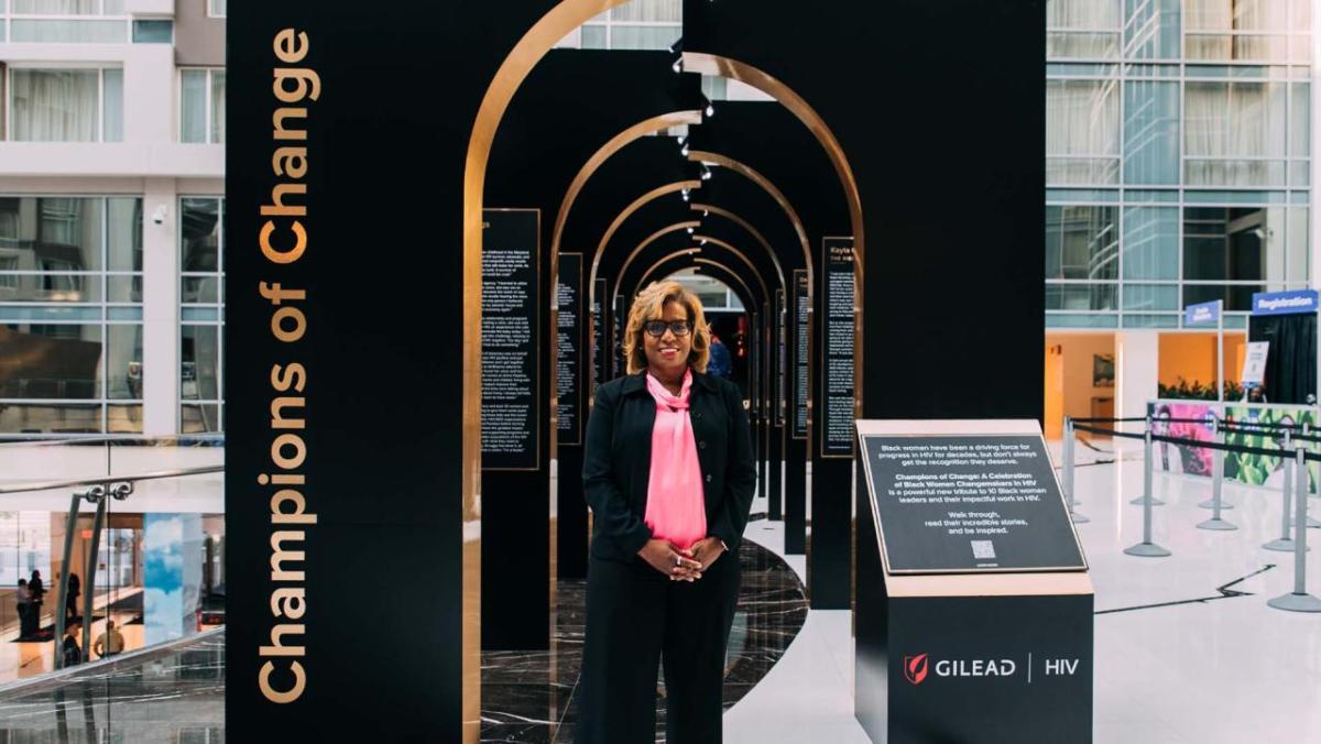 Deborah Telman in front of an artistic display "Champions of change" on the side.