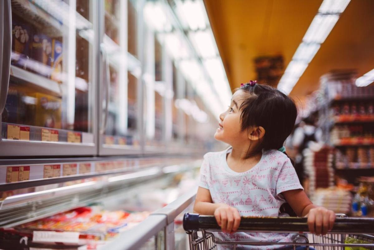 A child seated in a shopping at looking at items