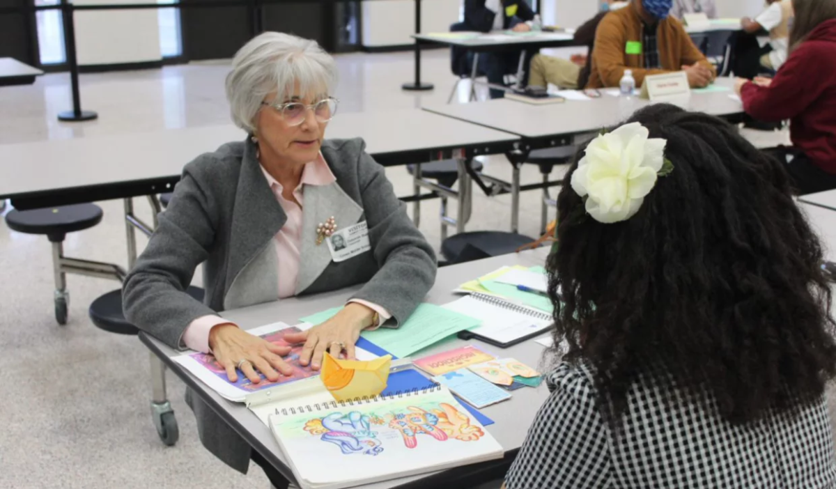 Retired GP employee Deborah Baker talking with a student