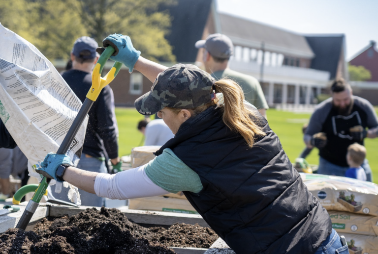 People digging in raised garden beds.