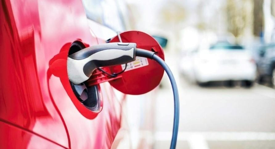 A red electric vehicle plugged in.