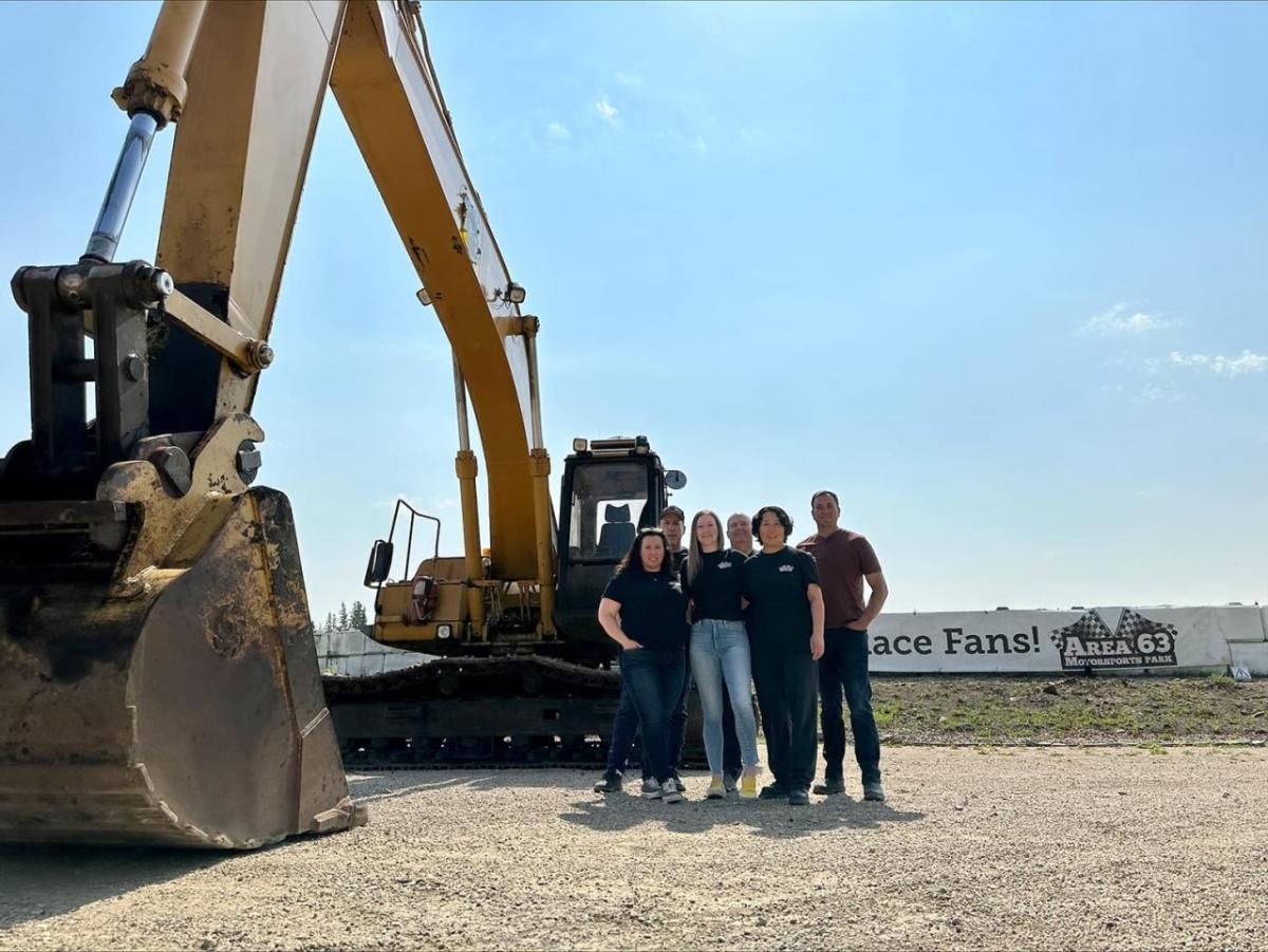 Group of people next to a large piece of construction equipment