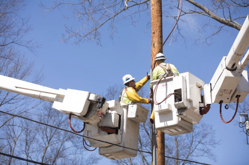 Workers in cherry pickers working together