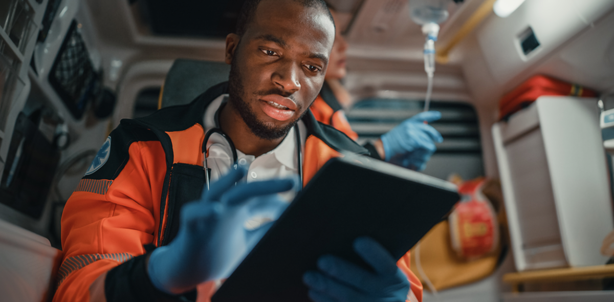 a first responder using a tablet in the back of an ambulance