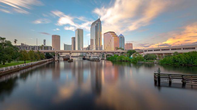 Skyline view of a water way leading to tall buildings in the background.