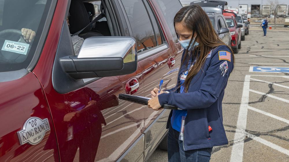 Driver speaking with food bank volunteer who is holding a clipboard