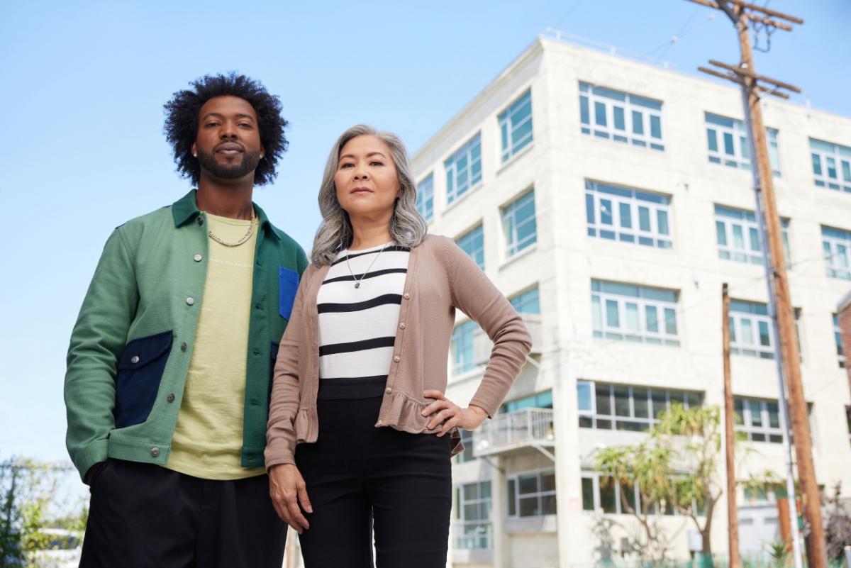 2 people standing in front of a building