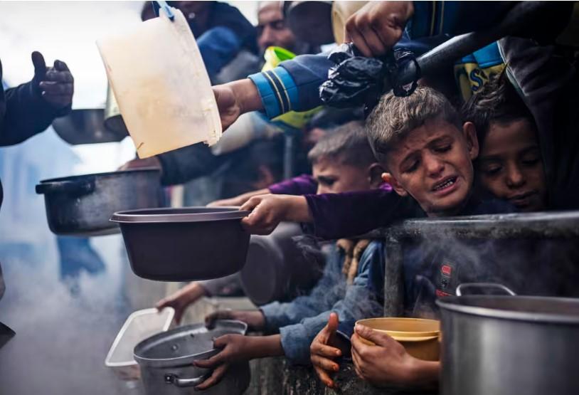 Palestinians line up for free meals in Rafah, Gaza, on Feb. 16. // Photo by Fatima Shbair / AP file