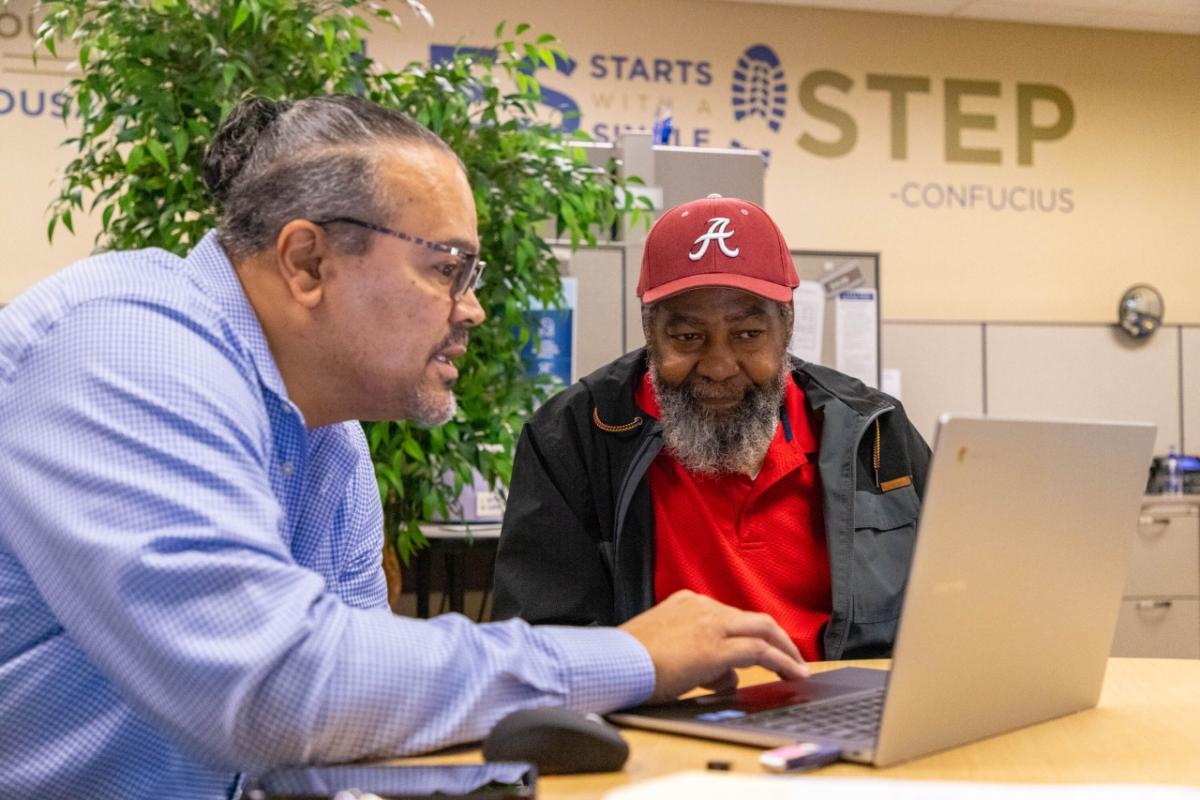 Two people seated in front of a laptop