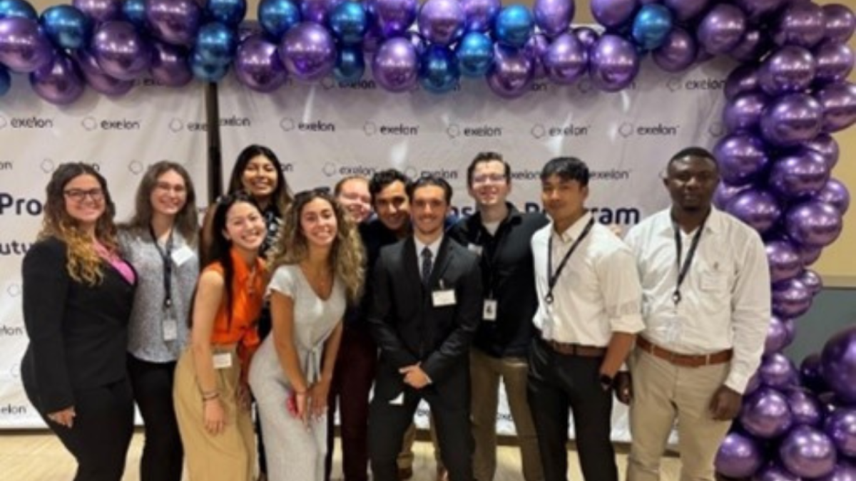 A group of people stood together in front of a balloon arch