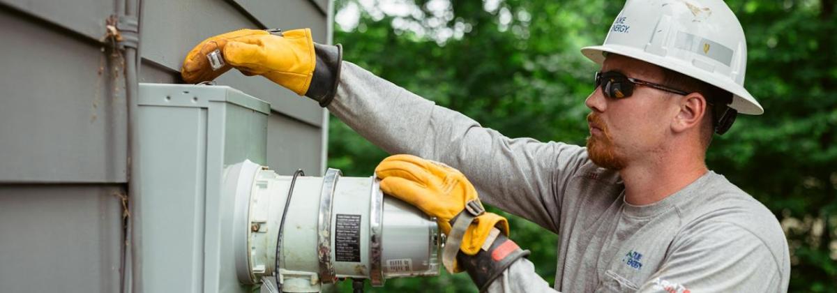 Harrison Cochran working on an electrical box, wearing protective gear.