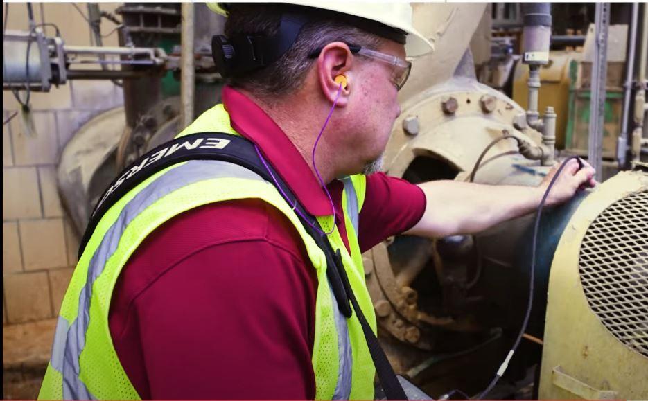 Worker in hard hat at a machine