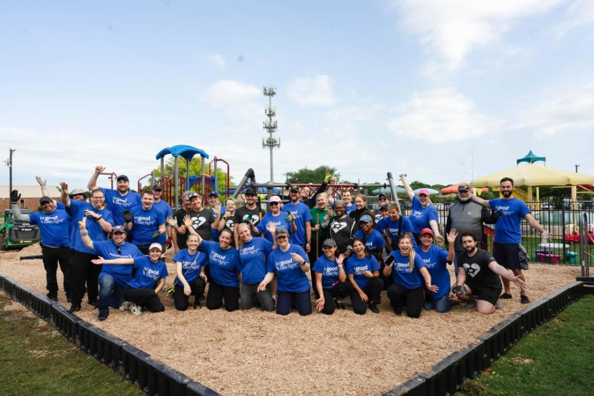A large group photo in front of a playground 